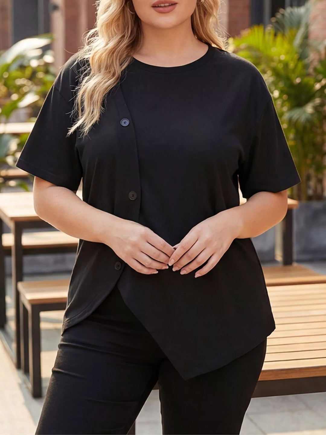 Black Plus-size short sleeve top with asymmetrical button hem
