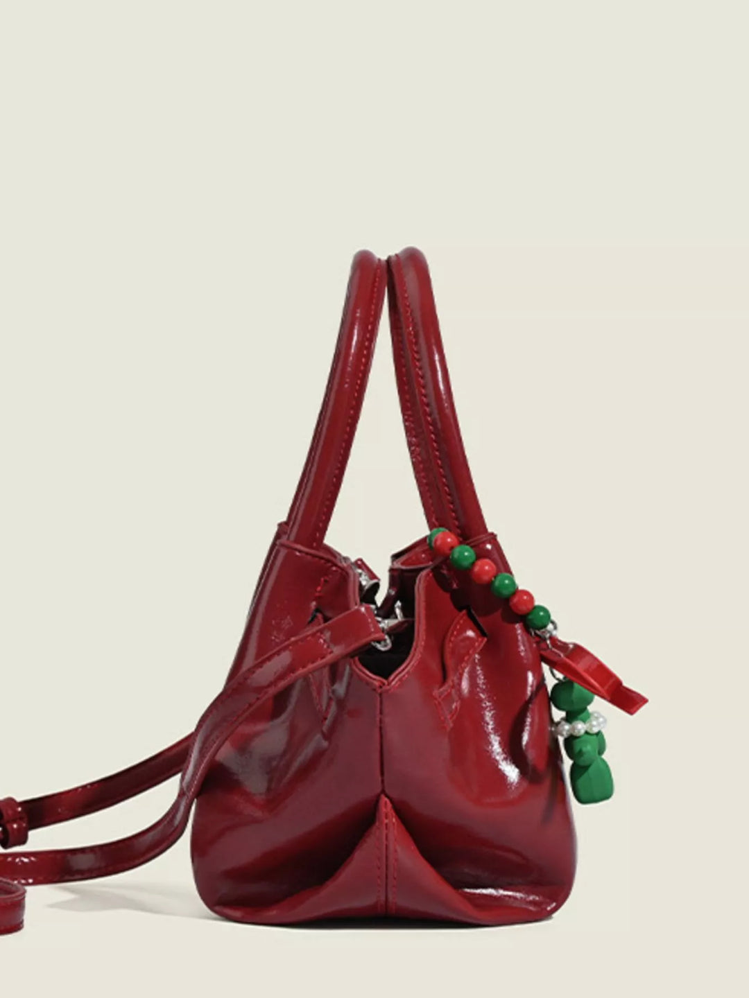 Glossy slouchy top handle crossbody bag with beaded charm