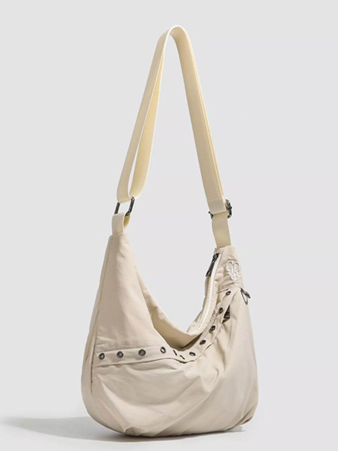 Grommet-studded nylon crossbody sling bag with zip pockets