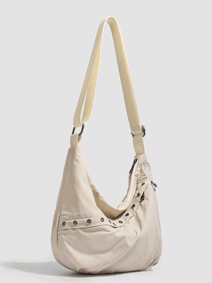 Grommet-studded nylon crossbody sling bag with zip pockets