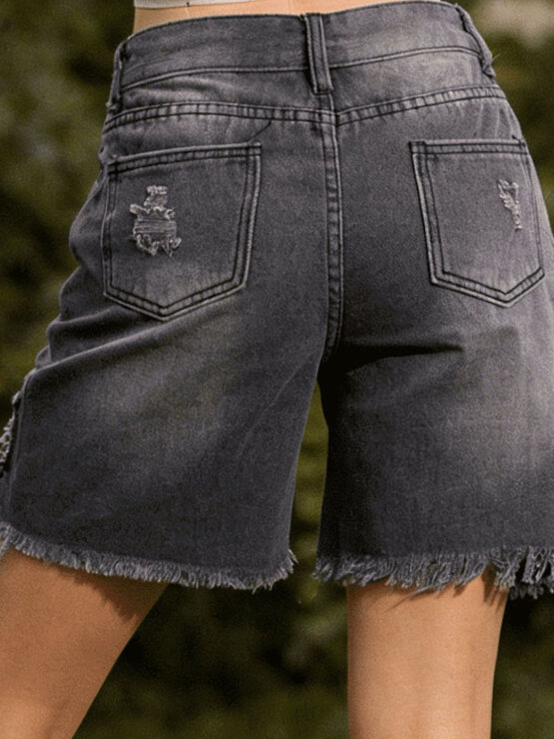 Distressed mid-thigh denim shorts with raw frayed hem