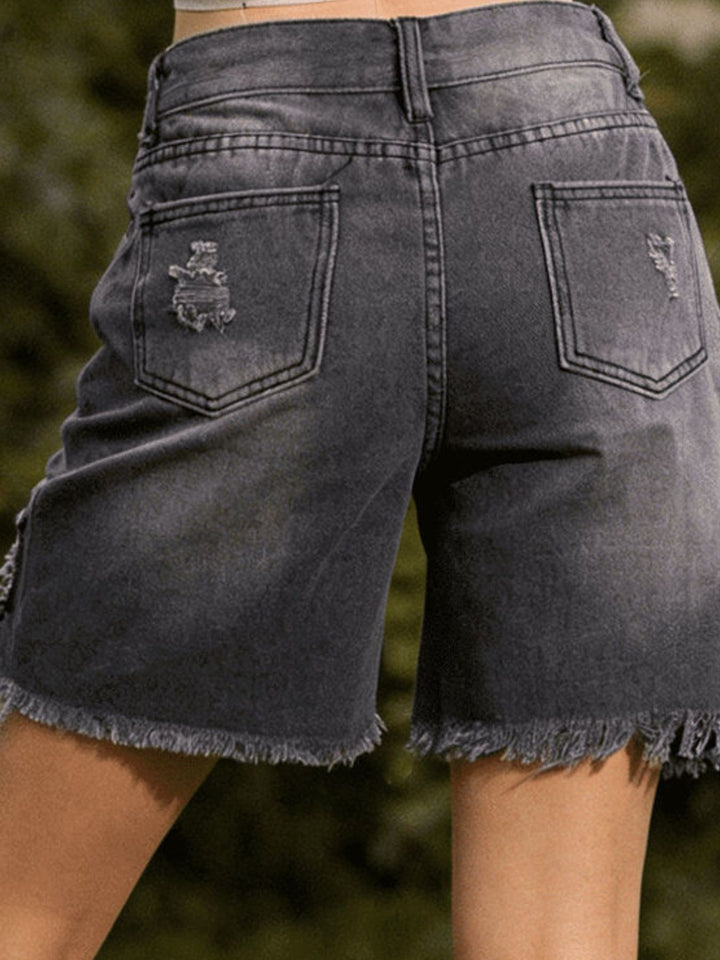 Distressed mid-thigh denim shorts with raw frayed hem