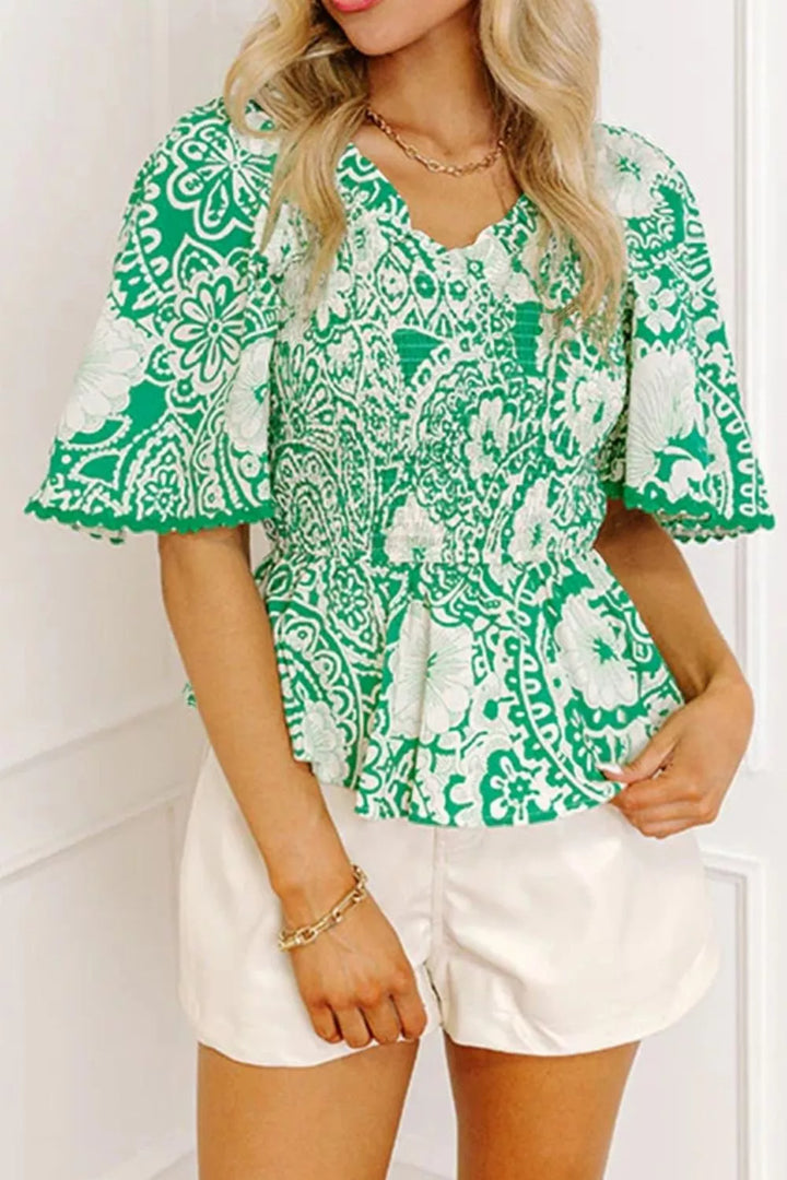 Smocked V-neck floral peplum blouse with flutter sleeves
