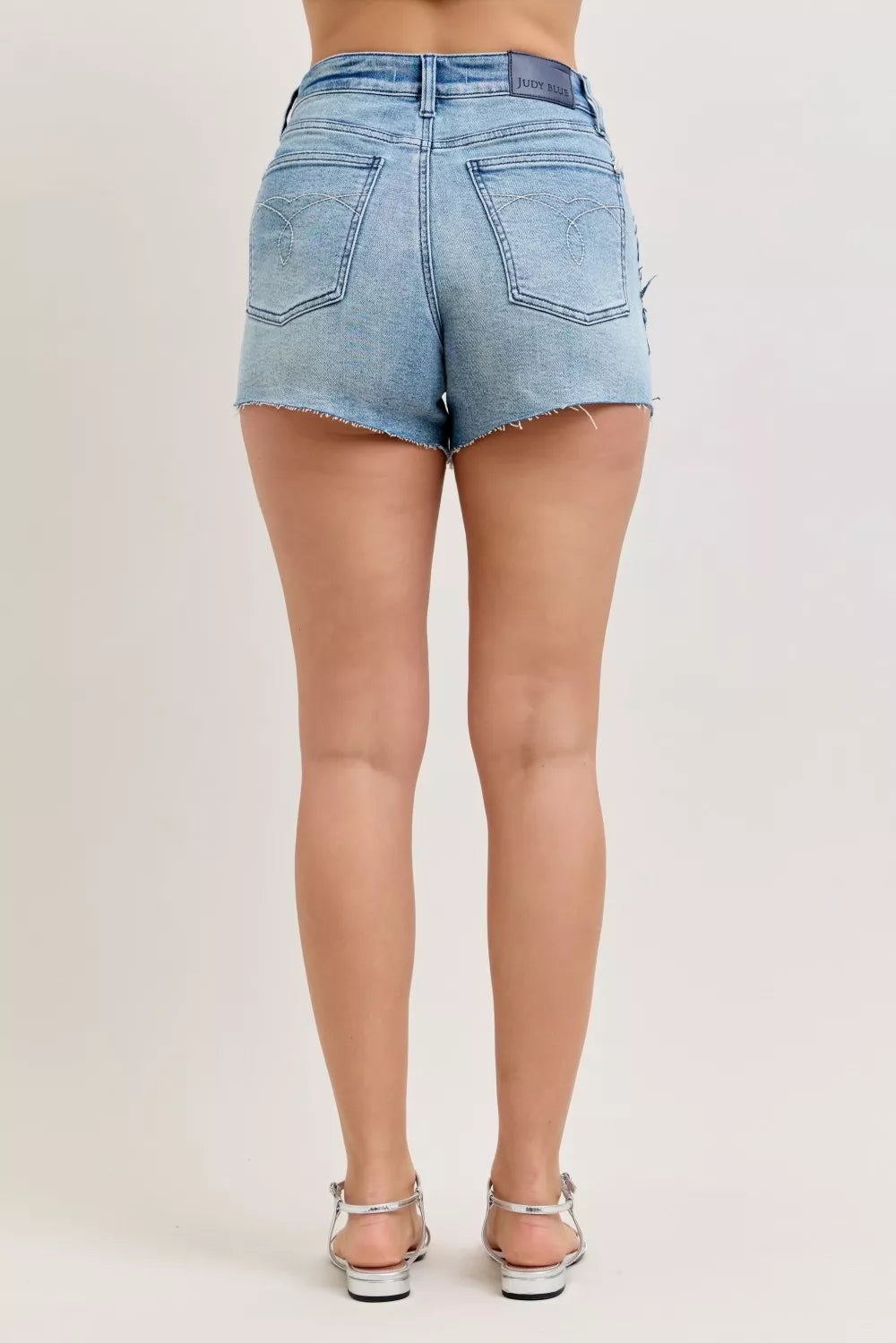 High-rise rigid denim cutoff shorts with raw frayed hem
