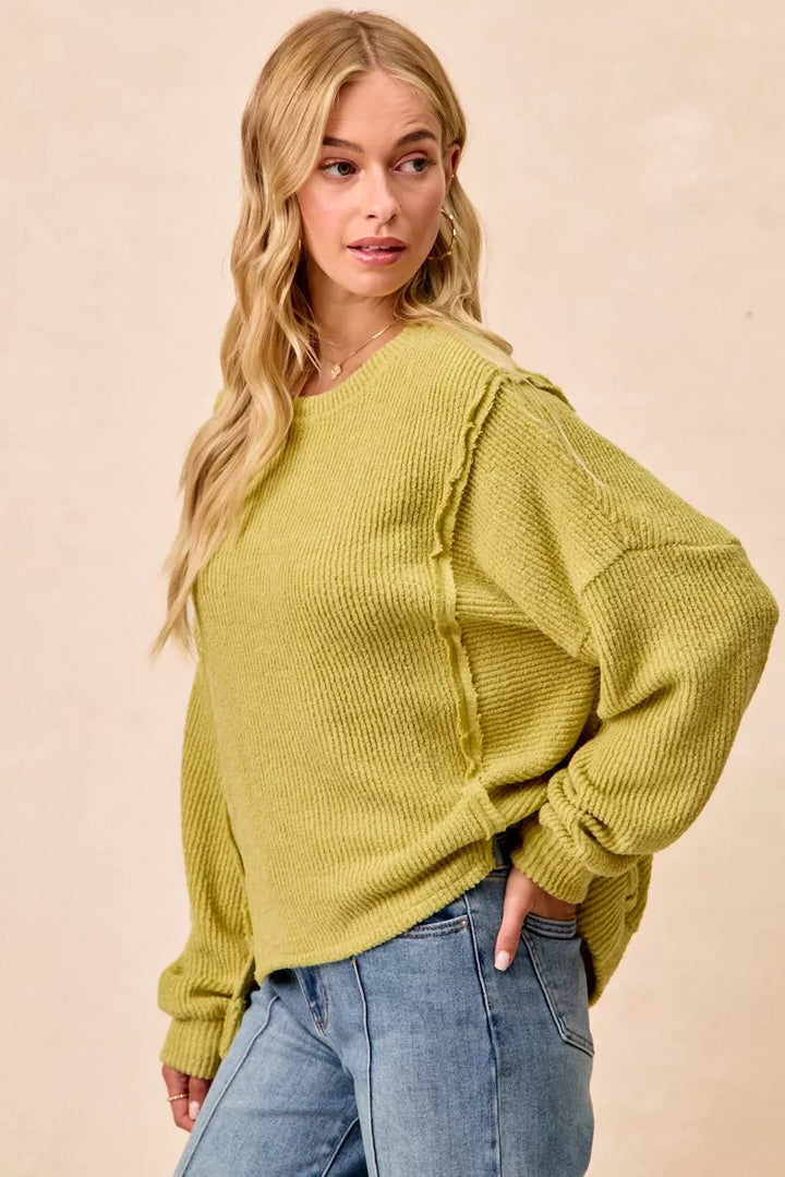 Ribbed boucle knit sweater with exposed seams and uneven hem