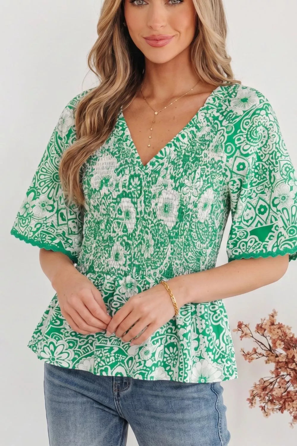 Smocked V-neck floral peplum blouse with flutter sleeves