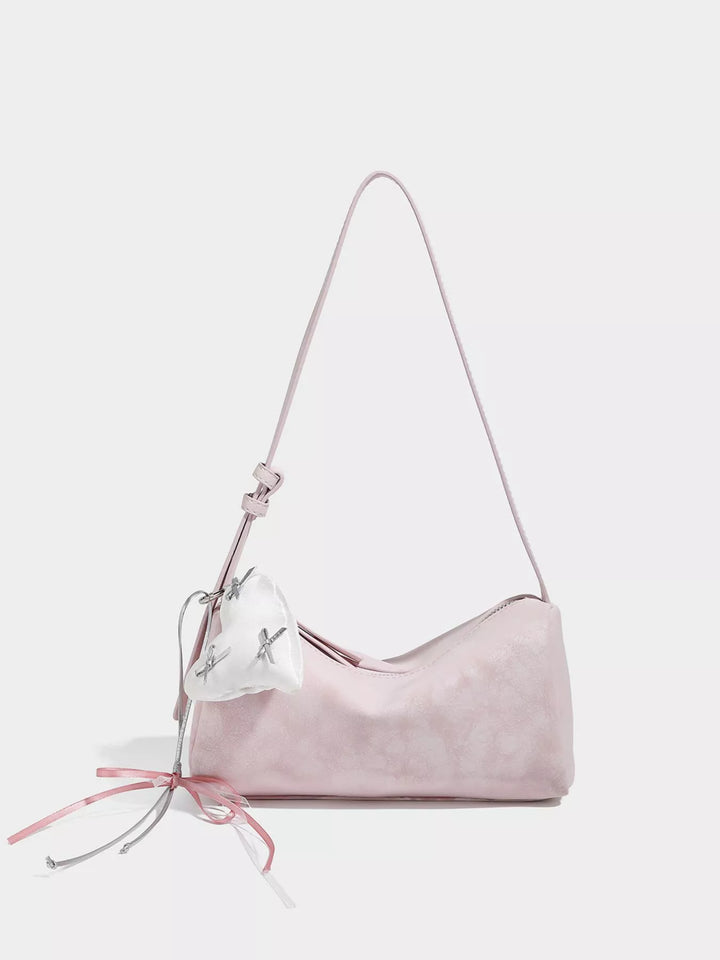 Adjustable strap crossbody bag with heart charm and bow trim