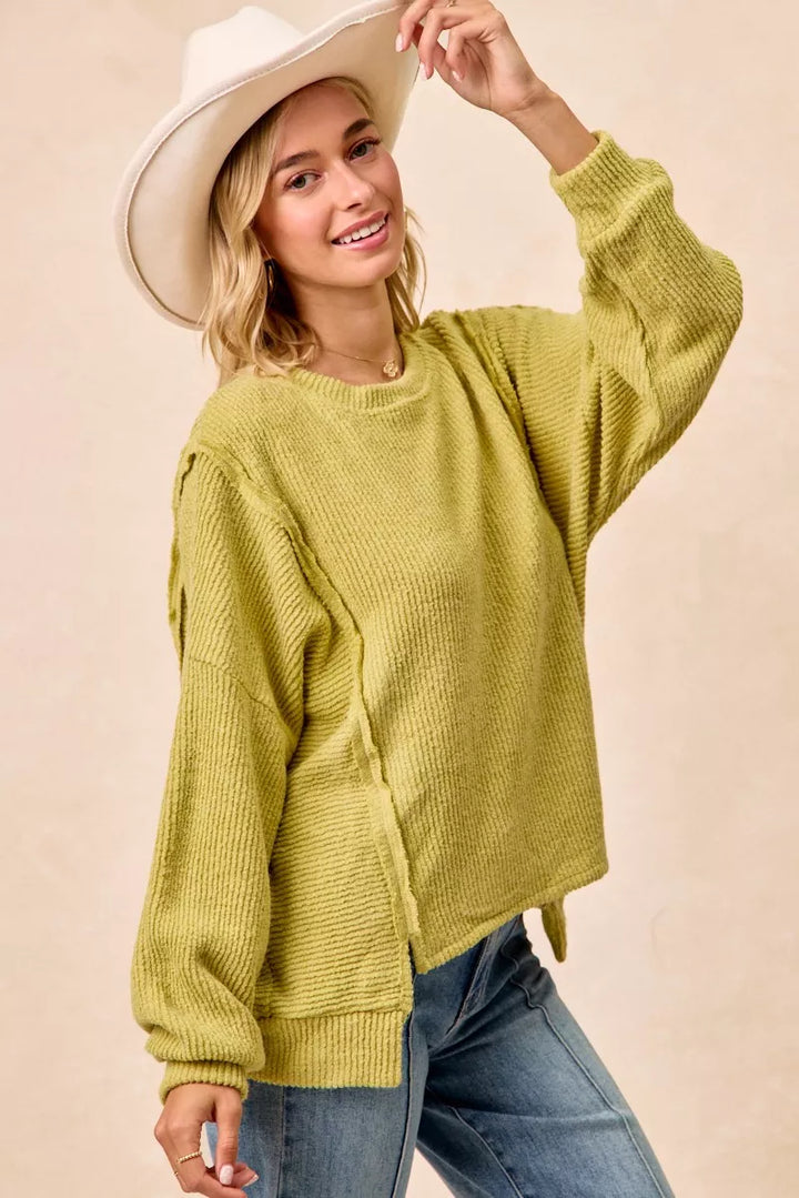 Ribbed boucle knit sweater with exposed seams and uneven hem