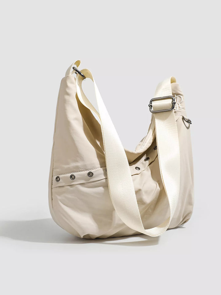 Grommet-studded nylon crossbody sling bag with zip pockets