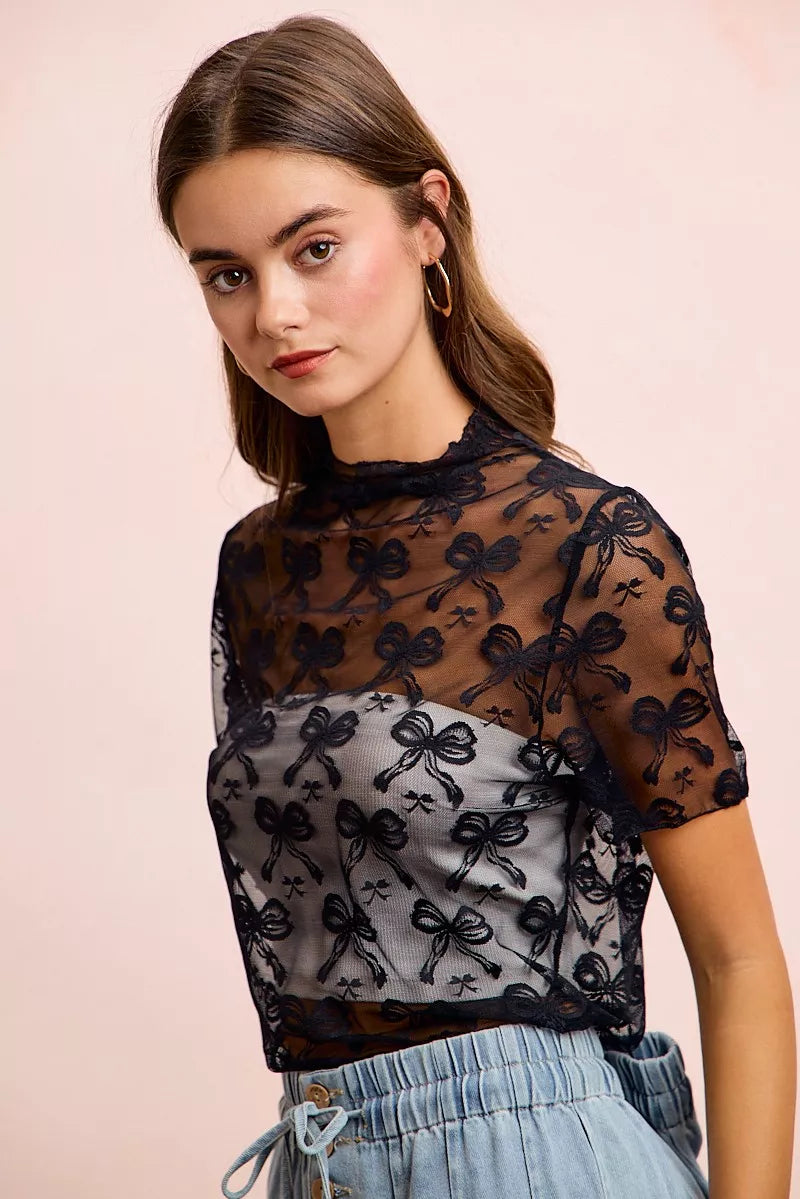 Sheer mesh mock-neck top with allover bow pattern