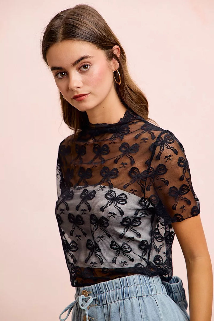 Sheer mesh mock-neck top with allover bow pattern