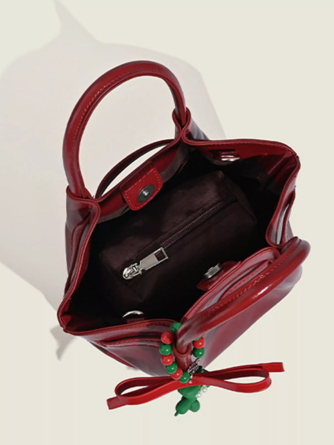 Glossy slouchy top handle crossbody bag with beaded charm
