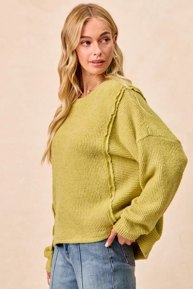 Ribbed boucle knit sweater with exposed seams and uneven hem