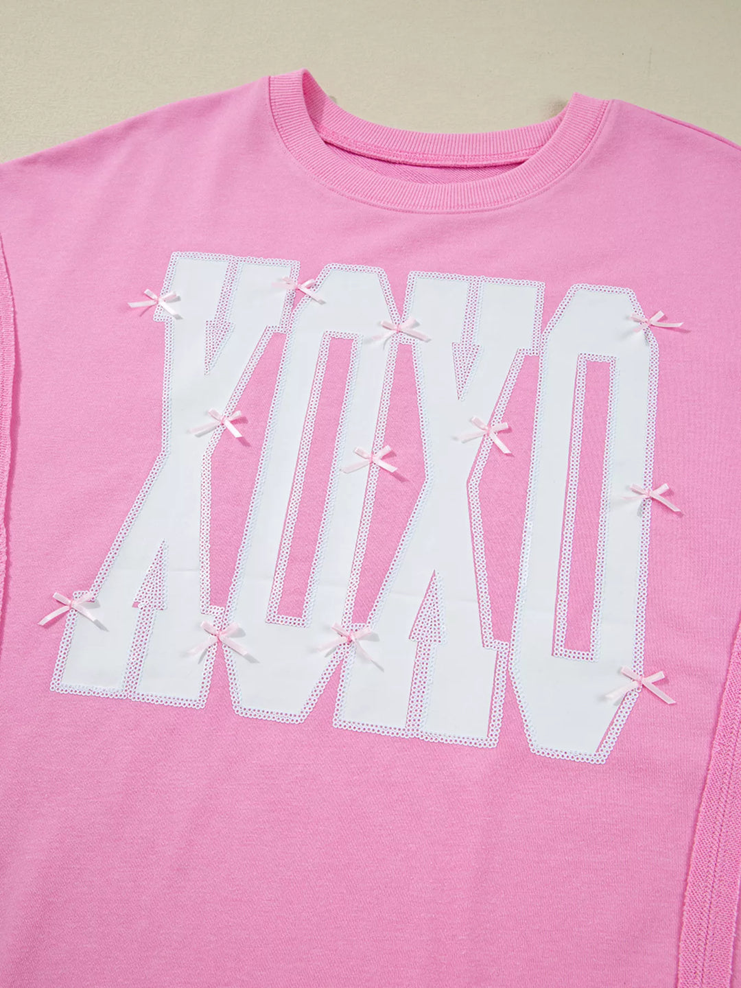 Oversized XOXO graphic sweatshirt with exposed seams and bows