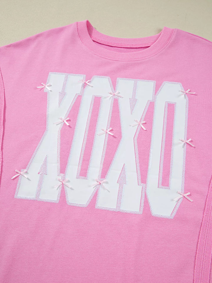 Oversized XOXO graphic sweatshirt with exposed seams and bows
