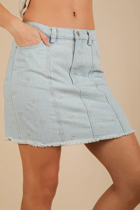 Bow-embroidered denim mini skirt with raw hem
